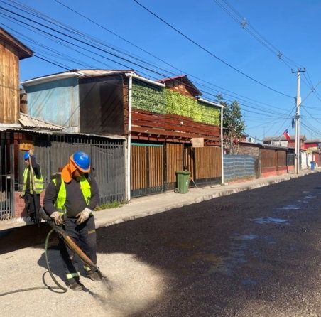 Trabajador aplicando riego de liga sobre la calzada